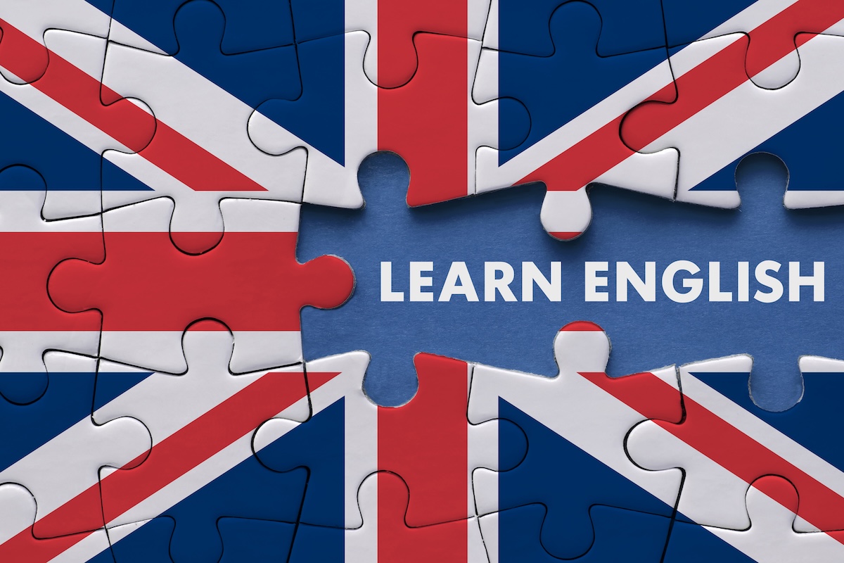 Ein Puzzle mit der britischen Flagge, in dessen Mitte ein fehlendes Teil den Schriftzug „Learn English“ freigibt Britische Flagge als Puzzle und Slogan "Learn English" – Business-Englisch verbessern und im Beruf durchstarten!